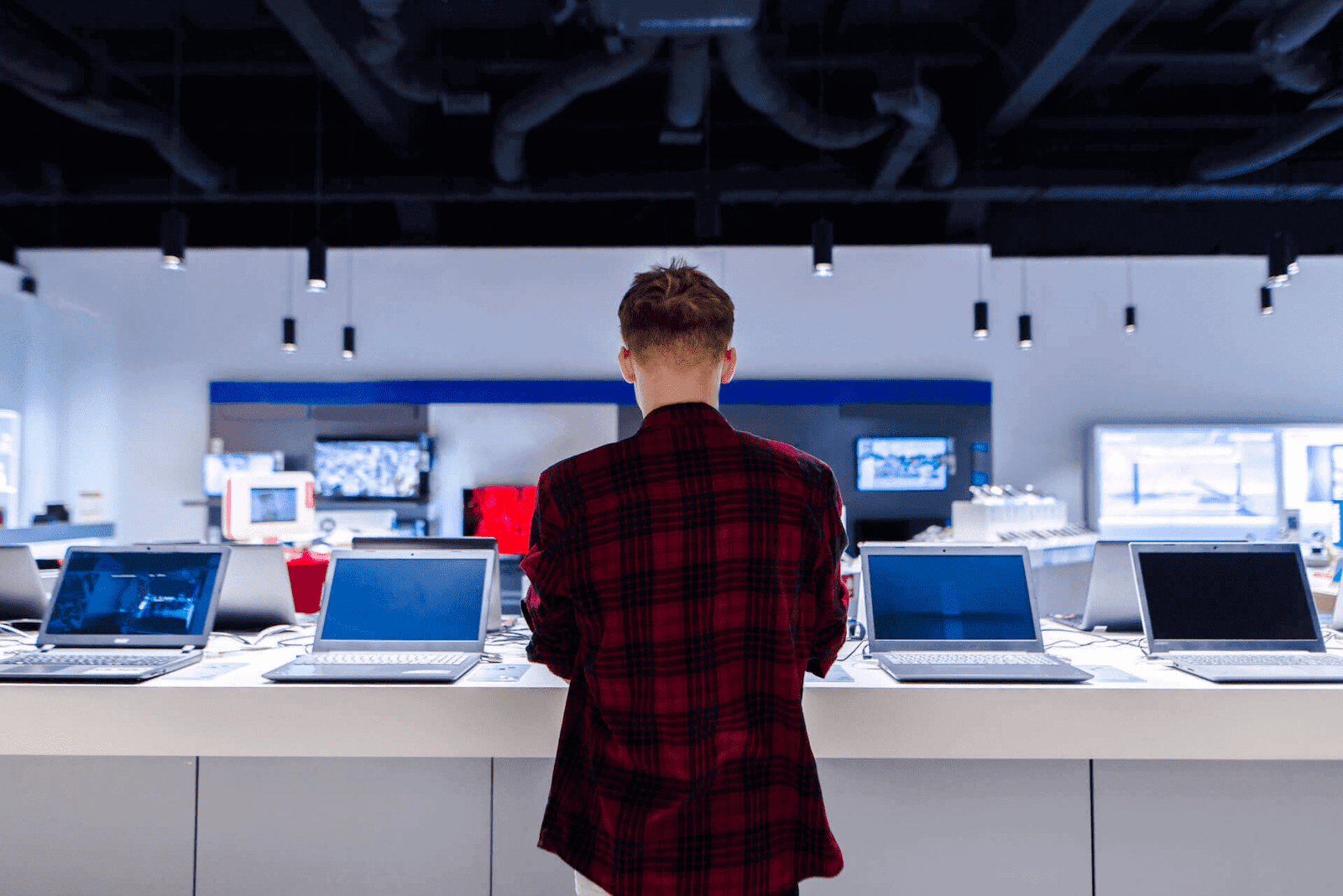 Customer browsing laptops at computer retail shop